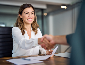 Woman in white blouse reaching out and shaking hand